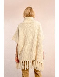 Turtleneck poncho with pompoms